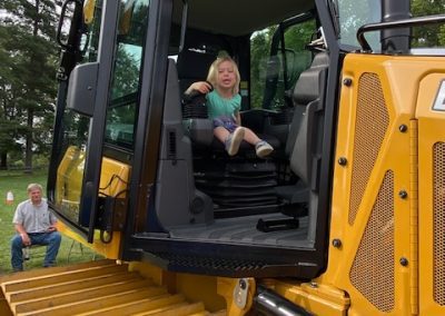 Child boards a heavy machinery display by Comer Construction at the National Night Out in Harford County