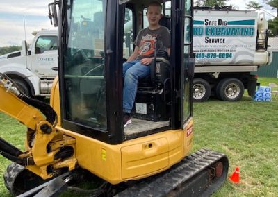Kid boards a heavy machinery display by Comer Construction at the National Night Out in Harford County