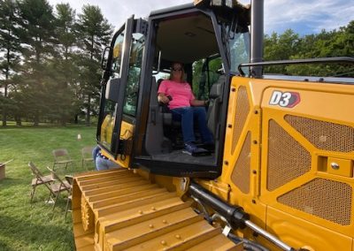 Woman poses on a heavy machinery display by Comer Construction at the National Night Out in Harford County