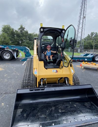 A boy poses on a bulldozer
