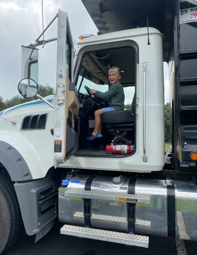 A boy on a Comer Construction dump truck display.