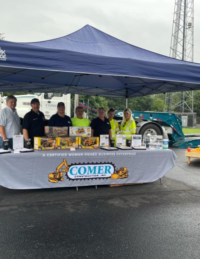 Comer Construction employees pose in the booth.