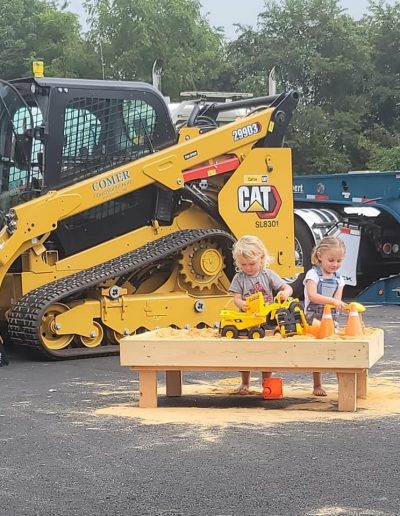 Children play with toy trucks on sandbox