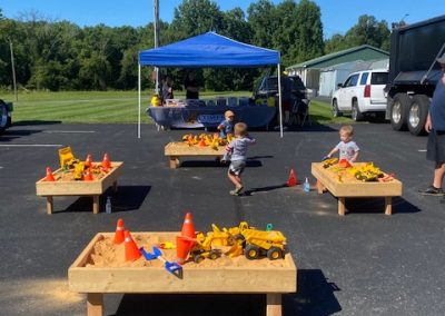 Curious children inspecting a variety of construction vehicles at a Touch-A-Truck event, discovering the wonders of the machinery world.